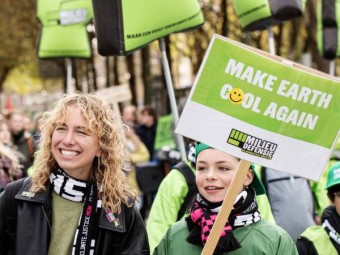 Mensen lopen mee met de Klimaatmars. Op een bordje staat: Make Earth Cool Again.